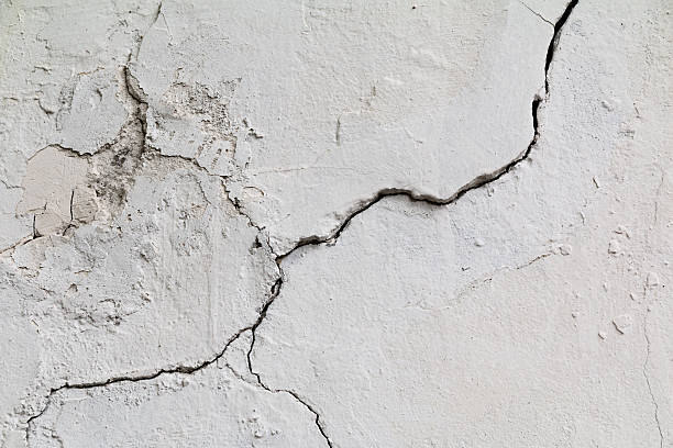 istock Crack. Texture of old painted white plaster. Cracked wall. 577648806
