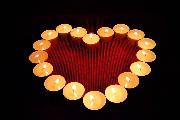 istock lovely heart shape of small candle lights 577649090