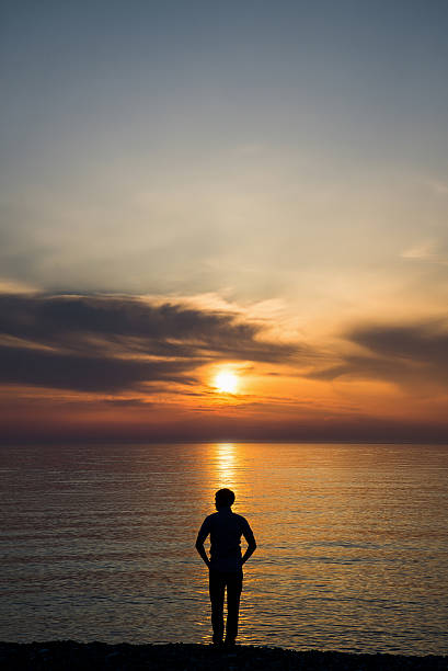 istock Young man standing at the beach in front of amazing 577651014