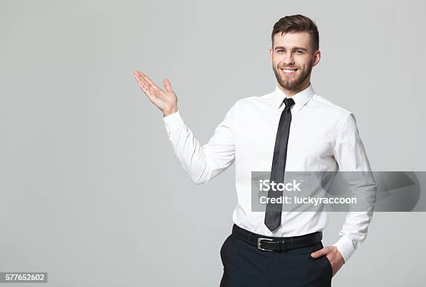 Handsome Young Businessman Holding His Arm Up Presenting Copyspace Stock Photo - Download Image Now
