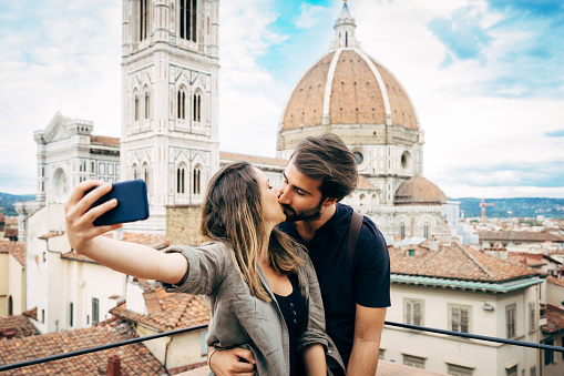 Young couple kissing in front of Florence's cathedral