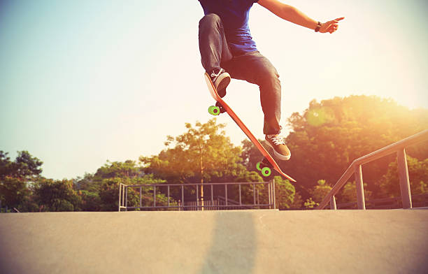 young woman skateboarder skateboarding at skatepark young woman skateboarder skateboarding at skatepark Ollie stock pictures, royalty-free photos & images