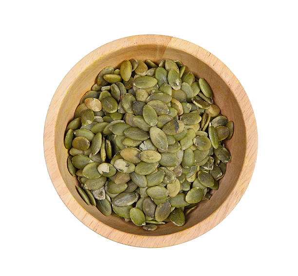 istock pumpkin seed in a wooden bowl on a white backg 577655428