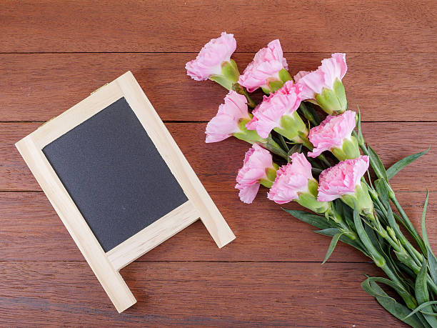 istock Black board and sweet pink Carnation flower 1 577655512
