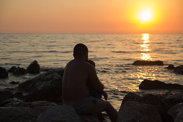 istock father and son at sunset on the sea 577656274