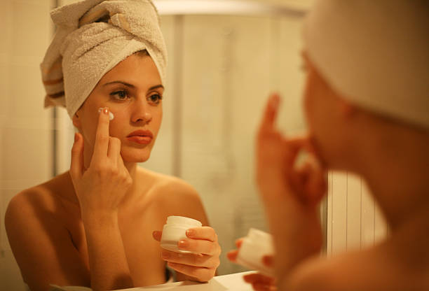 istock Woman applying cream to face. 577657314