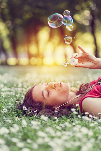 Young woman blowing soap bubbles