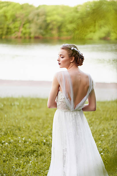 istock Beautiful girl in white long dress with open back 577658830