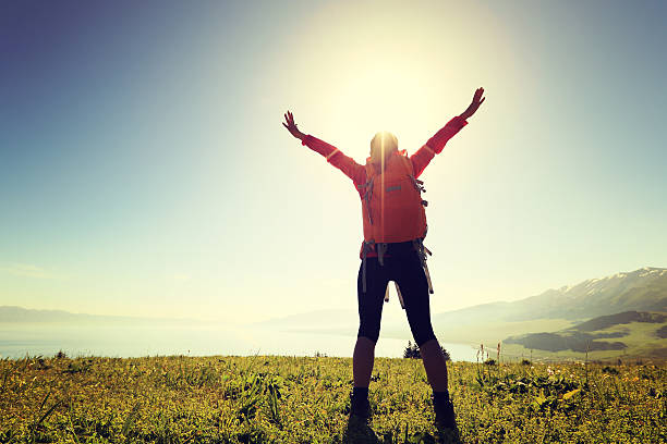 istock cheering successful woman backpacker open arms on mountain peak 577659718