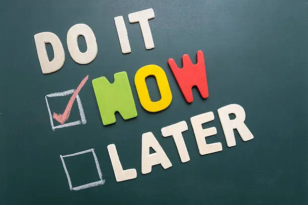 Photo of Do It Now or Later with checkbox on blackboard