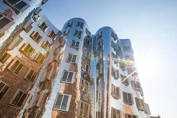 Frank O. Gehry's Neuer Zollhof buildings at MedienHafen, Dusseldorf Düsseldorf, Germany - March 26, 2016: famous distorted buildings at medienhafen designed by famous american architect Frank O. Gehry's. the building complex consists of three separate buildings and was completed in 1998. picture contains lensflares. düsseldorf photos stock pictures, royalty-free photos & images