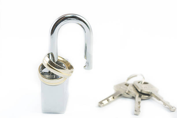 Wedding rings on opened shiny padlock Wedding rings on opened shiny padlock and keys on white background. Concept for marriage problems divorcee stock pictures, royalty-free photos & images