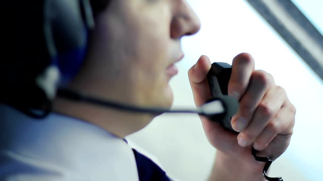 Airman talking to co-pilot by walkie-talkie and discussing flight details