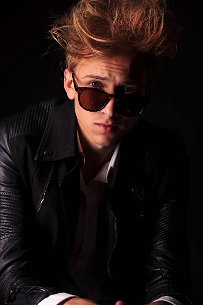istock young fashion man looking over his suglasses. 577933282