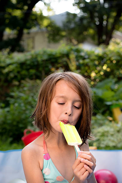 istock Caucasian girl eating popcicle in pool 577935906
