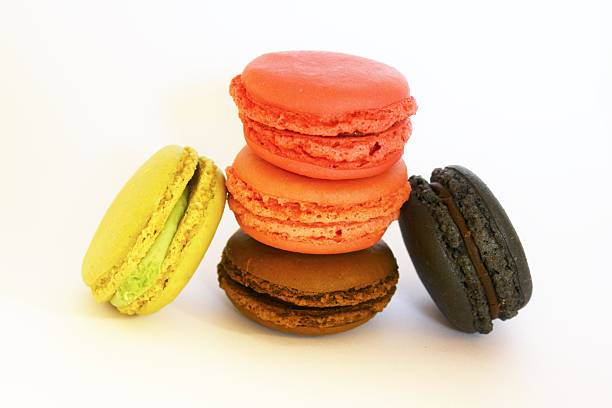Five french macarons in pink, black, brown and green color stock photo