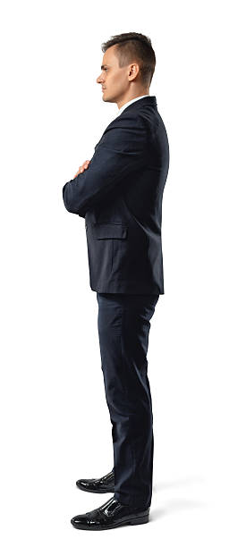 istock Side view of young businessman with his arms folded looking 577939644