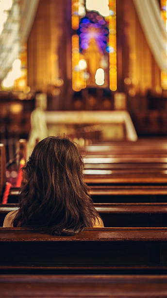 istock woman praying in church 577941632