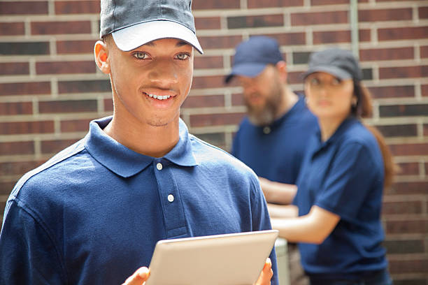 Air conditioner repairmen work on home unit. Blue collar workers.