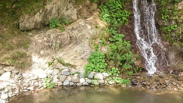 Waterfall in the mountains in Krasnaya Polyana, Sochi, Roza Khutor, summer in June 2016