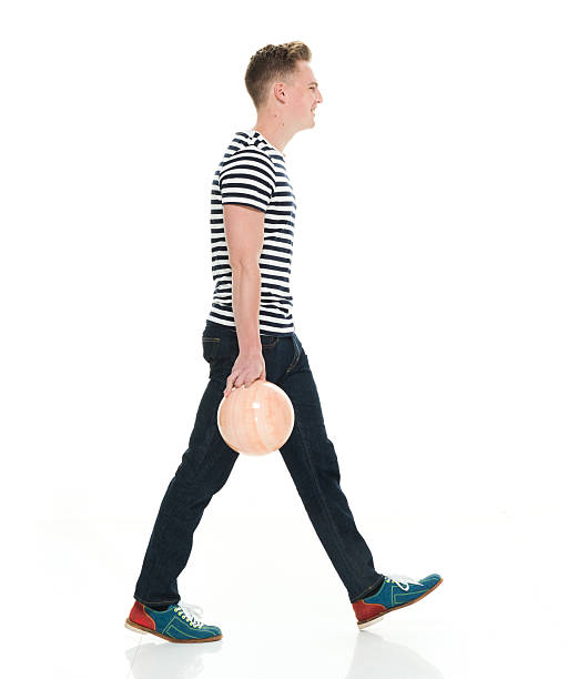 улыбающийся мужчина, идущего с шаром для боулинга - bowling isolated sportsman vertical стоковые фото и изображения