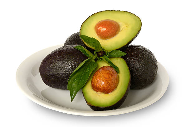 istock Whole Half Hass Avocados Basil Leafs Round White Plate Background 577949648