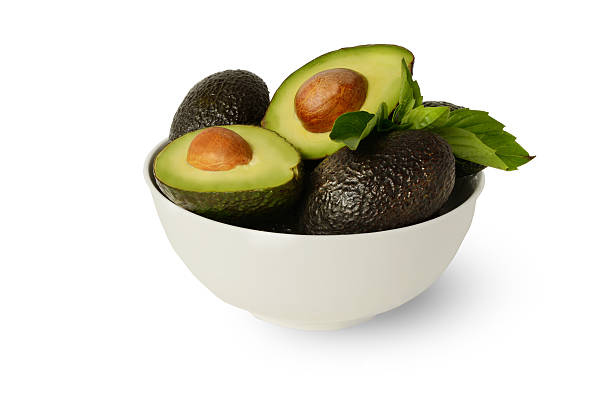 Whole Half Hass Avocados Basil Leafs White Bowl and Background