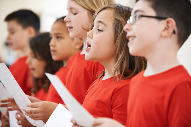 groupe d'enfants chantant en chœur ensemble  - singing lesson photos et images de collection