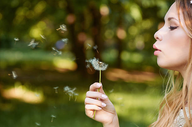 istock Girl blowing on a dandelion, ease. the smile  the face 577950454