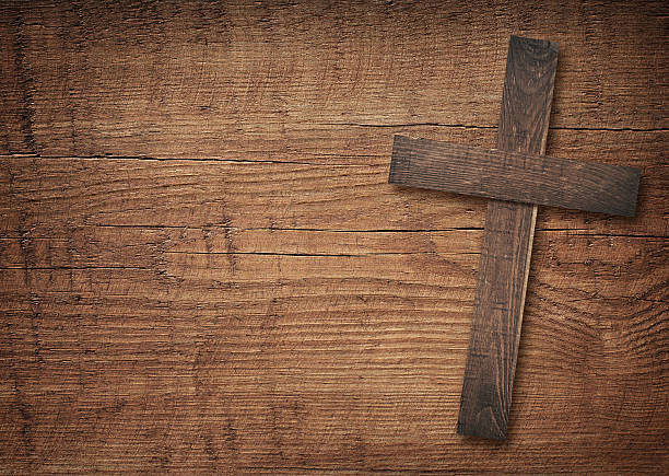 istock Wooden cross on brown old table top 577950996