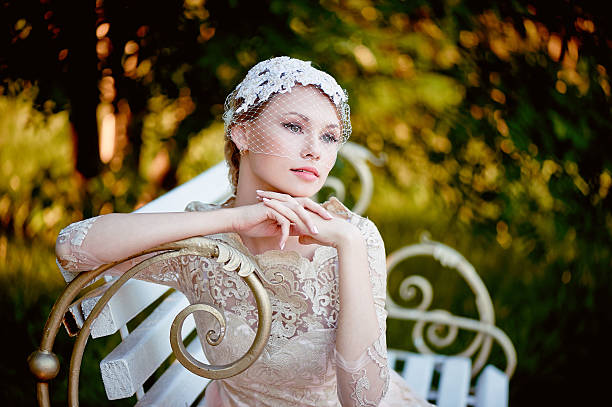 istock blonde with a hairstyle and veil sitting on bench, romantic 577951356
