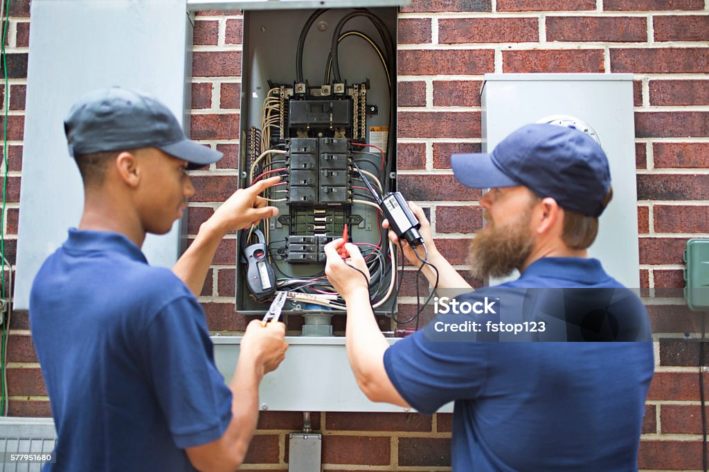 Reparadores, electricistas trabajando con disyuntor de su hogar. - Foto de stock de Electricista libre de derechos