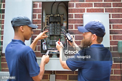 istock Repairmen, electricians working on home breaker box. 577951680