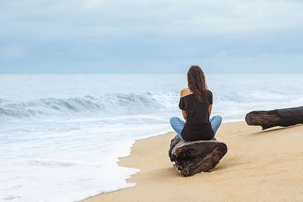 istock Lonely woman sitting on the tropical beach 577953336