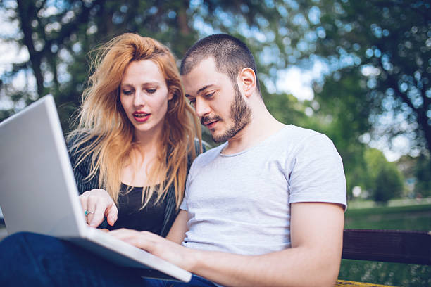 istock Lovers working with laptop outdoors 577953558