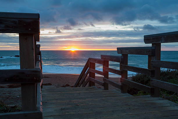 Passi per la spiaggia con tramonto - foto stock