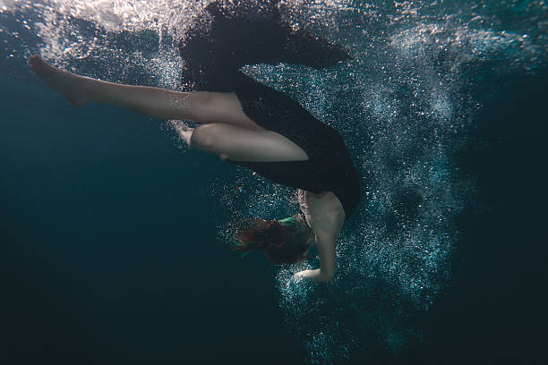 istock Woman dress dives underwater. 577954710