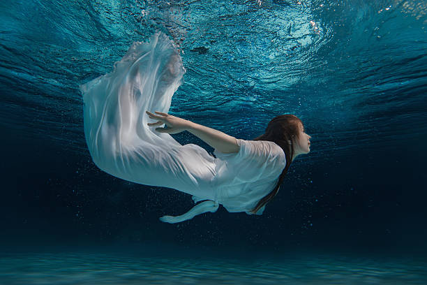 девушка в белом платье под водой. - swimming pool sensuality women sex symbol стоковые фото и изображения