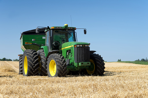 Elmira, Ontario, Canada - July 20, 2016: Farm equipment in a recently harvested field of wheat in rural Southwesten Ontario.