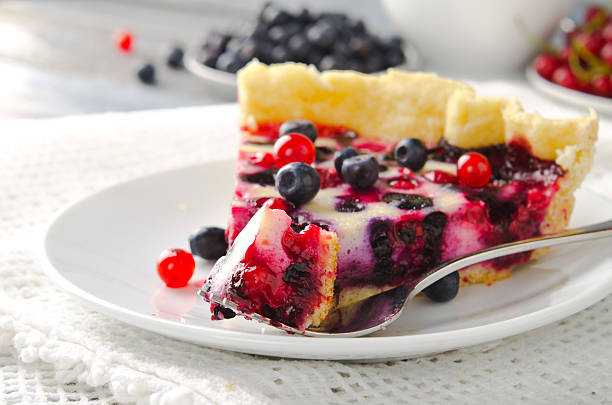 Mix berry tart, pie, cake with raspberries, bilberries, bluberries, red currant and cream on white background
