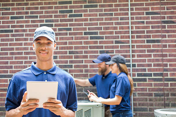 istock Air conditioner repairmen work on home unit. Blue collar workers. 577959084