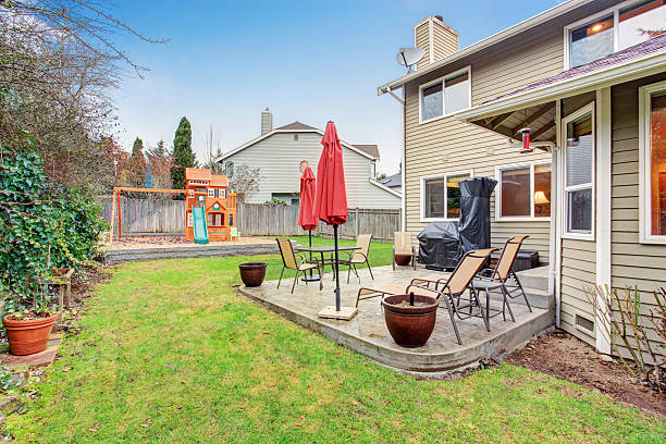 istock Backyard patio area with table set and closed red umbrella 577968088