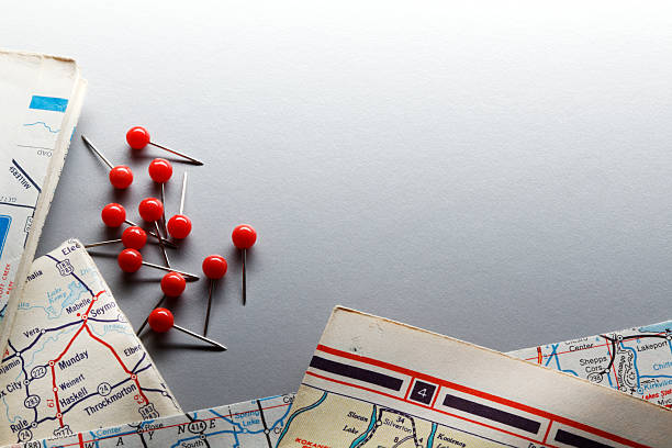 istock Group Of Push Pins Next To Stack Of Road Maps 577969342