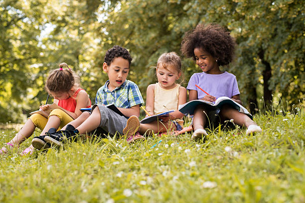 istock Four small friends relaxing in nature and writing in notebooks. 577971816