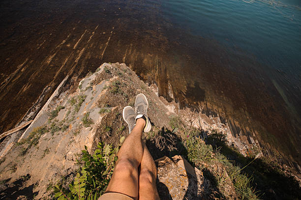 istock sitting male legs over the lake and rocks 577972312