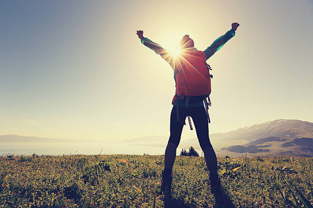 istock cheering successful woman backpacker enjoy the view on mountain peak 577972968