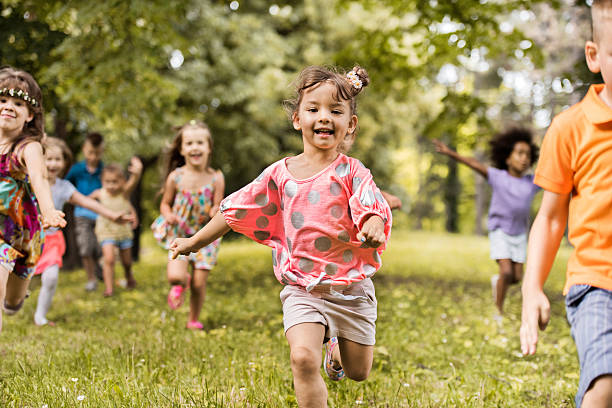 istock Happy little kid running with her friends in nature. 577973370