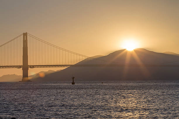 мост золотые ворота на закате - sun lighting equipment san francisco county downtown district стоковые фото и изображения