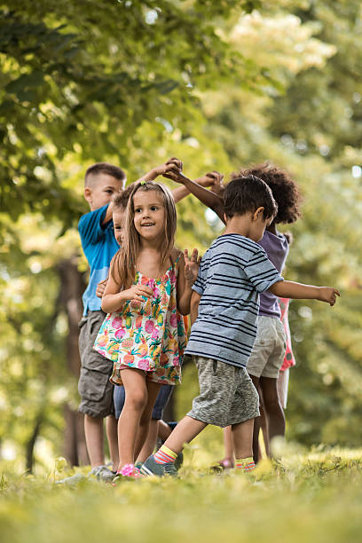 istock Group of small kids having fun while playing in nature. 577974568
