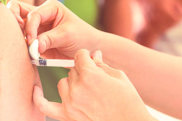 istock Shot of human hands making an injection with a syringe 577974584